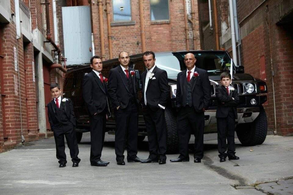 Groomsmen beside the limousine