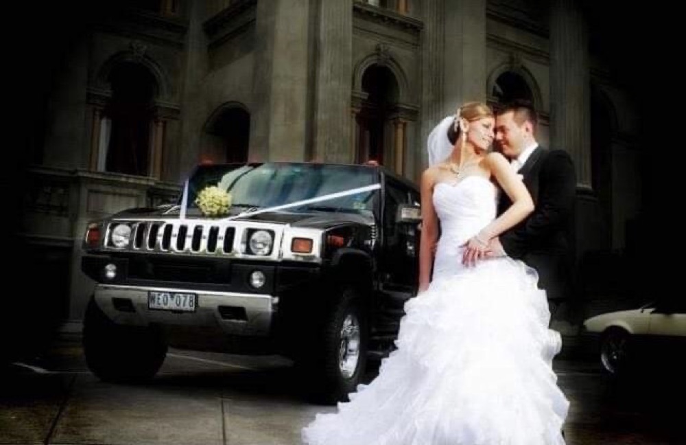Bride and groom beside the limousine